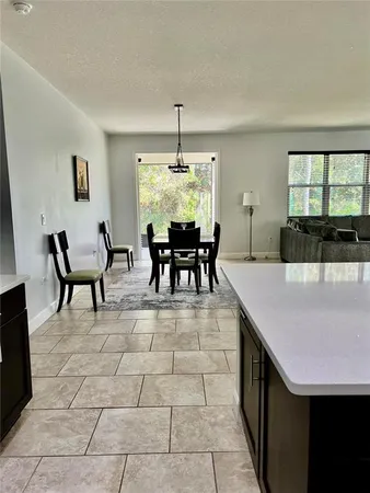 a dining room with granite countertop a table chairs and a chandelier