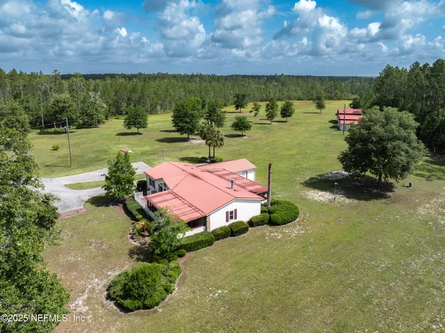 a view of house with garden and tall trees