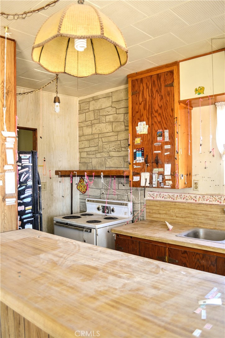 4040 Peter Rabbit Trail Twentynine Palms, CA 92277 - Photo 5 of 28 a view of a kitchen with stainless steel appliances kitchen island granite countertop a refrigerator and a sink