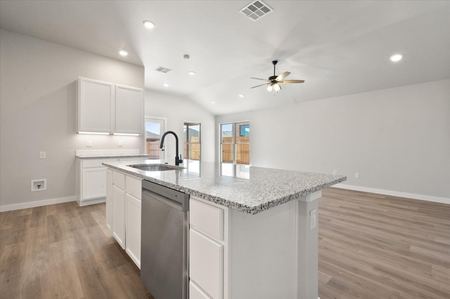 7429 30th Street Lubbock, TX 79407 - Photo 11 of 20 a kitchen with a sink cabinets and wooden floor