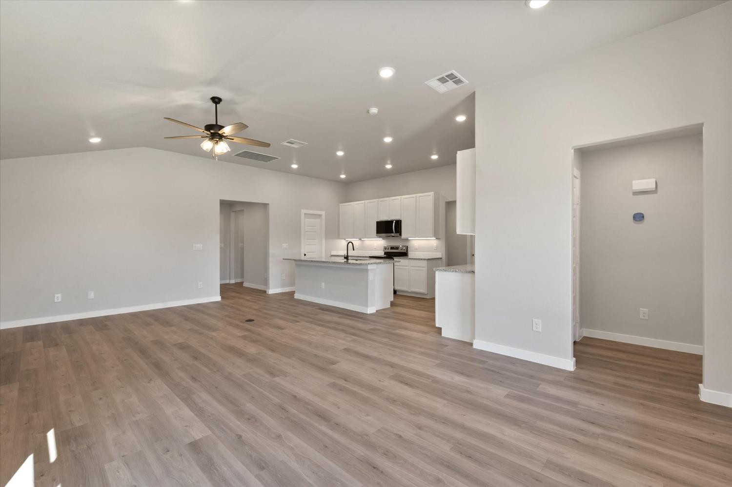 7429 30th Street Lubbock, TX 79407 - Photo 5 of 20 a view of an empty room and kitchen with wooden floor