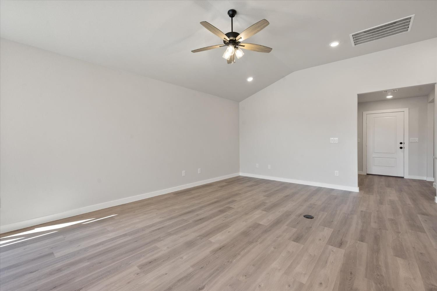 7429 30th Street Lubbock, TX 79407 - Photo 6 of 20 an empty room with wooden floor and a ceiling fan