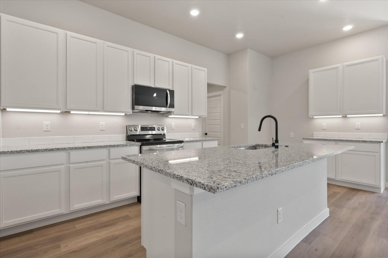 7429 30th Street Lubbock, TX 79407 - Photo 9 of 20 a kitchen with sink a microwave and cabinets
