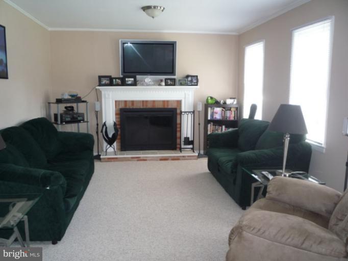 17221 Chiswell Road Poolesville, MD 20837 - Photo 12 of 23 a living room with furniture a flat screen tv and a fireplace