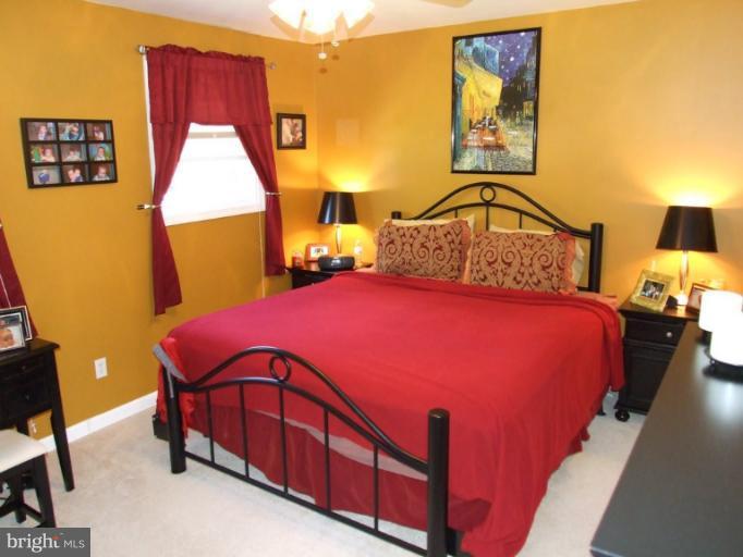17221 Chiswell Road Poolesville, MD 20837 - Photo 16 of 23 a bedroom with a bed next to a lamp on dresser and a window