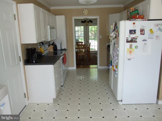 17221 Chiswell Road Poolesville, MD 20837 - Photo 9 of 23 a kitchen with a refrigerator and cabinets