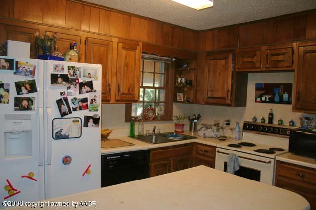 3625 South Travis Street Amarillo, TX 79110 - Photo 3 of 9 a kitchen with stainless steel appliances a stove a sink and a refrigerator