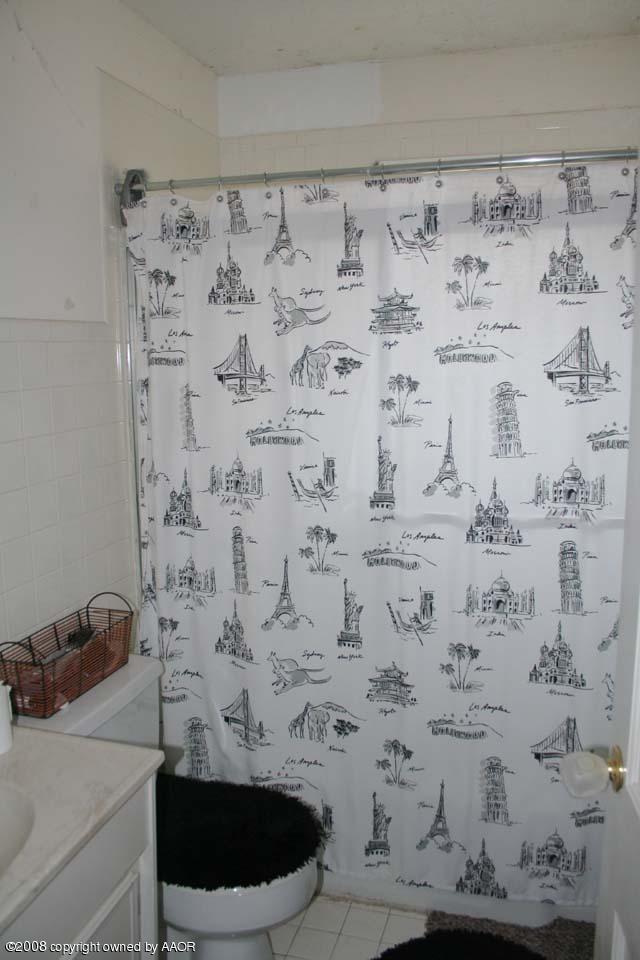 3625 South Travis Street Amarillo, TX 79110 - Photo 7 of 9 a bathroom with a bathtub and a shower