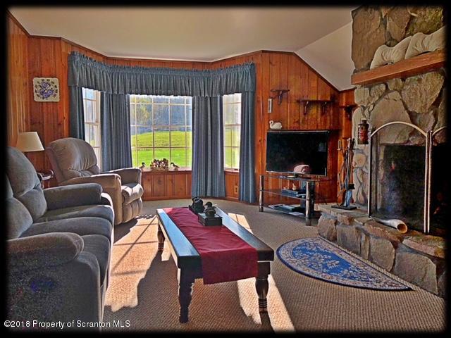1345 Phillips Road Springville, PA 18844 - Photo 9 of 54 a living room with furniture a flat screen tv and a floor to ceiling window