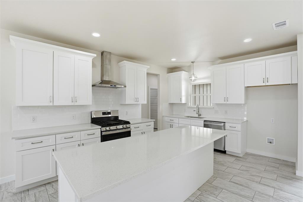 532 Highview Court Godley, TX 76044 - Photo 22 of 39 Spacious kitchen featuring an island, white shaker cabinetry, stainless steel appliances, a subway tile backsplash, and light-toned tile flooring