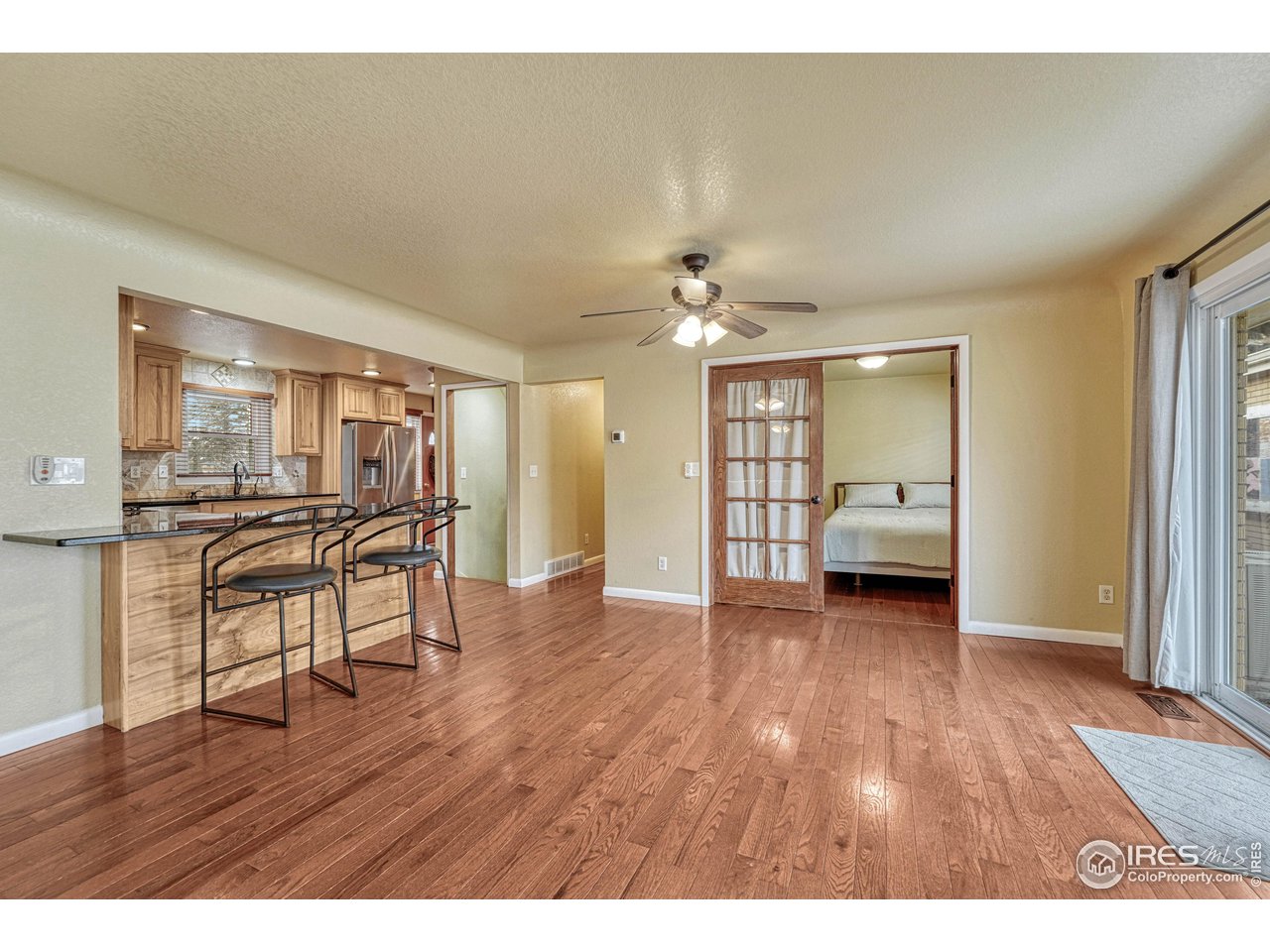 2518 Highland Road Greeley, CO 80634 - Photo 10 of 40 Dining areas flow into kitchen and 2nd bedroom on main level. All wood flooring.