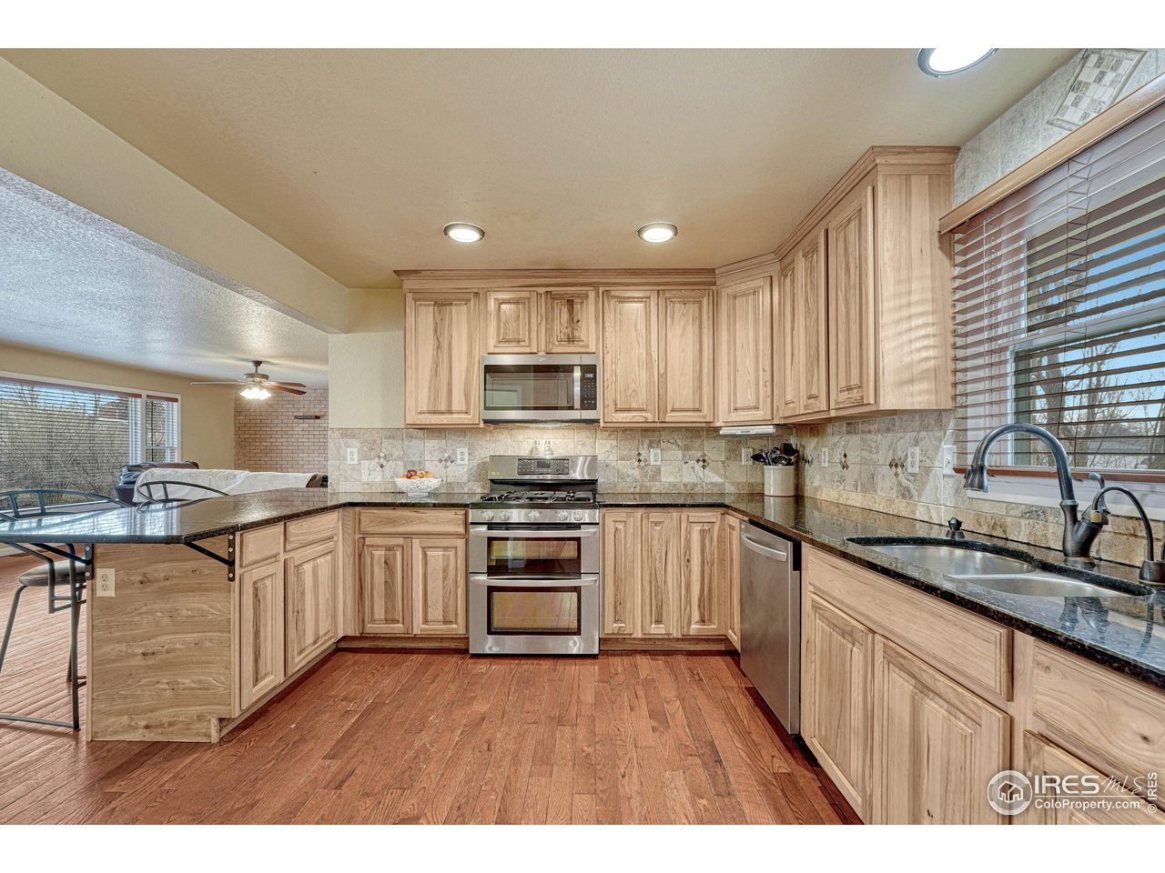 2518 Highland Road Greeley, CO 80634 - Photo 11 of 40 Upgraded kitchen with gas stove/double oven, black granite countertops, inset sink and hickory cabinetry.