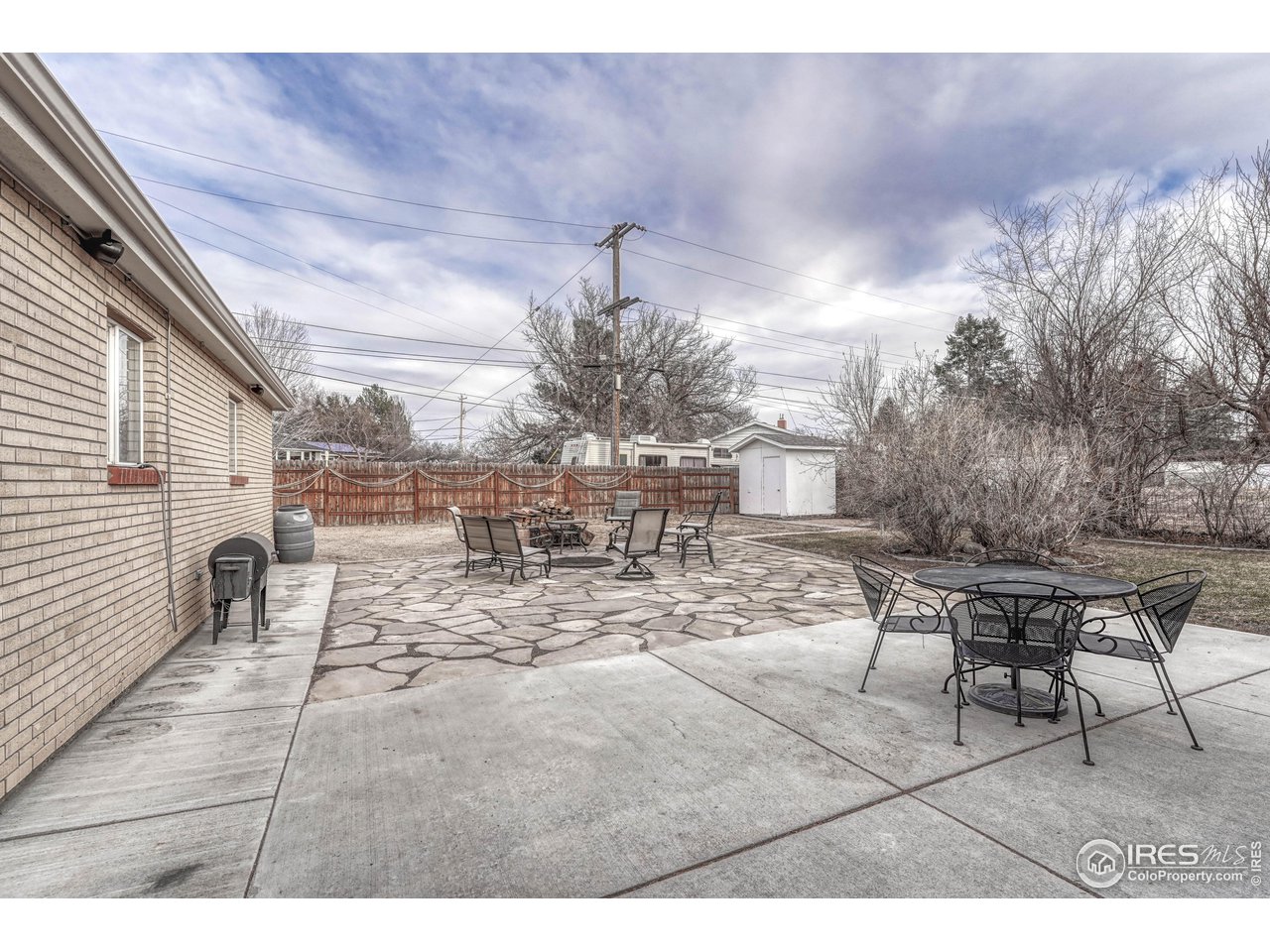 2518 Highland Road Greeley, CO 80634 - Photo 31 of 40 Back patio looking from sliding glass doors. So much privacy and space to entertain or enjoy between concrete patio and flagstone area with inset firepit