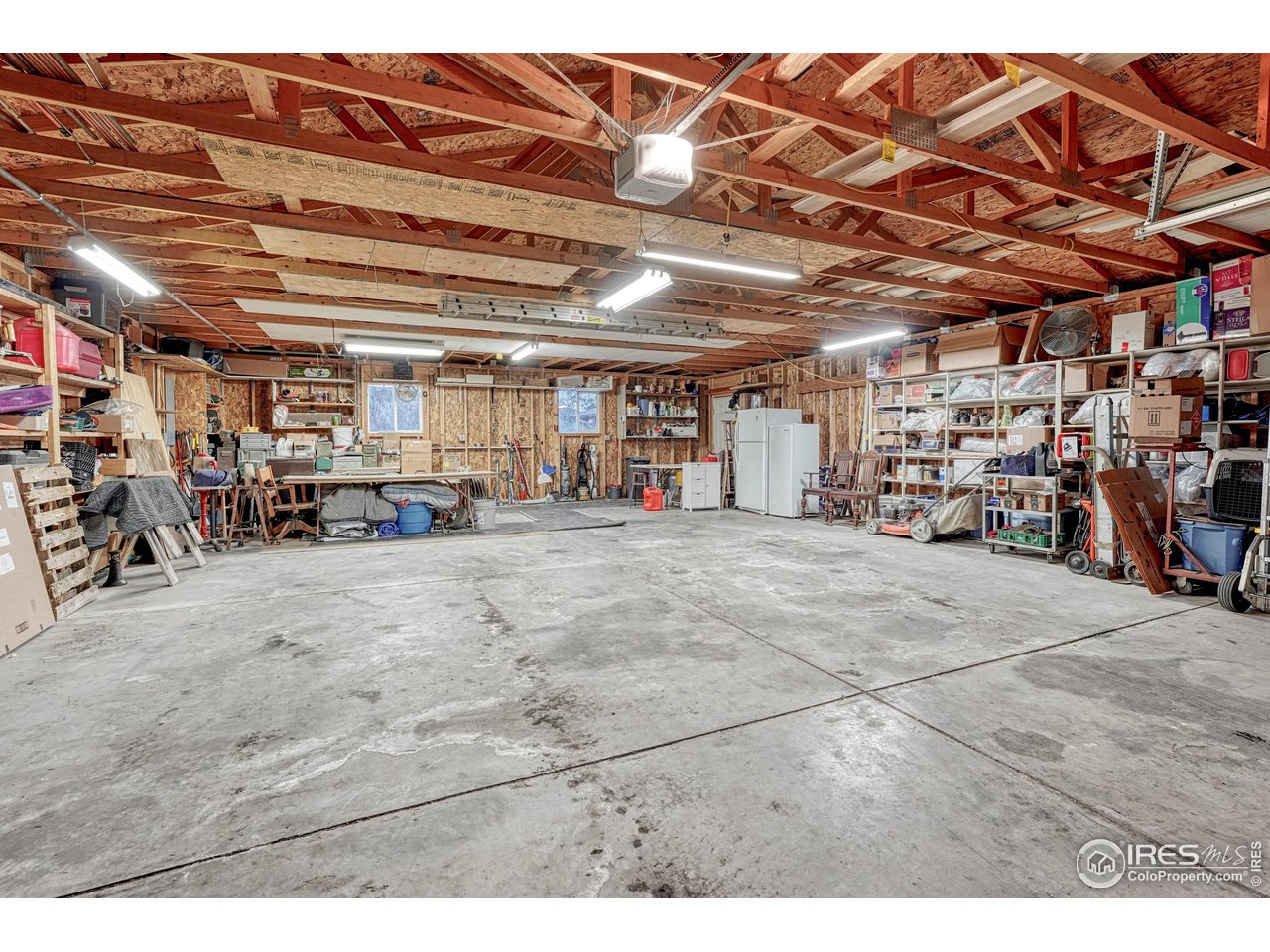 2518 Highland Road Greeley, CO 80634 - Photo 35 of 40 30x40 shop with built in shelves, concrete floor, windows and 2 doors.