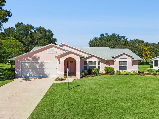 a front view of a house with a yard and trees