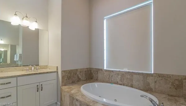 a bathroom with a sink a mirror and a bathtub