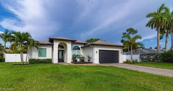 a front view of a house with a garden and yard