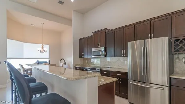 a kitchen with kitchen island a refrigerator and a sink