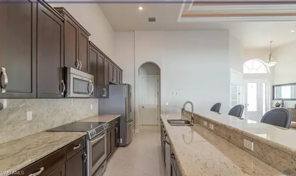 a kitchen with stainless steel appliances granite countertop a sink stove and cabinets