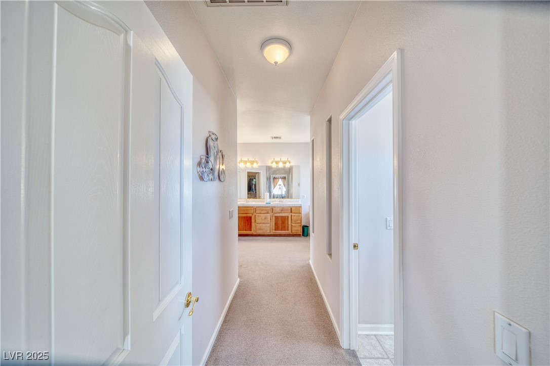 660 Indian Road Pahrump, NV 89048 - Photo 37 of 54 Short hallway to primary bathroom, from primary bedroom.