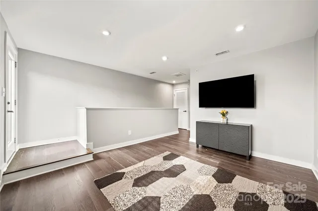 a living room with a flat screen tv and a rug