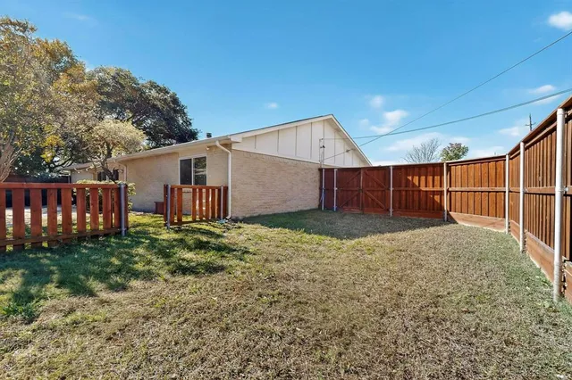 a view of backyard with wooden fence