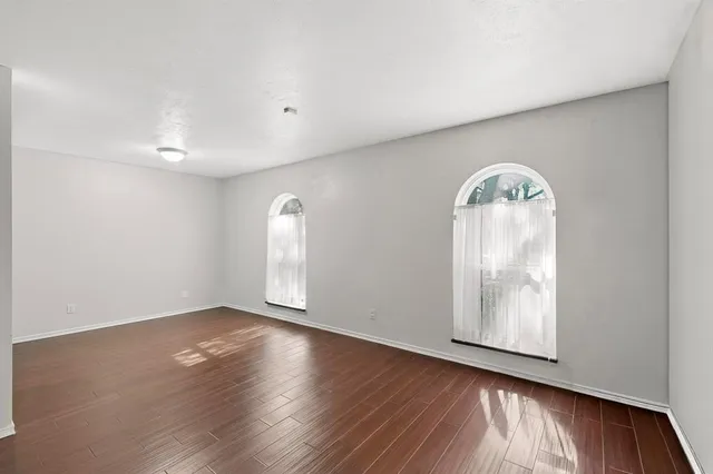 an empty room with wooden floor and a bathroom