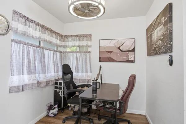 a view of a workspace with furniture and a window