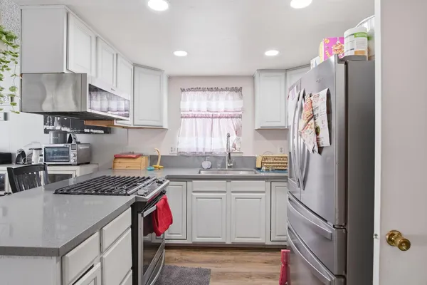 a kitchen with stainless steel appliances granite countertop a sink stove and refrigerator