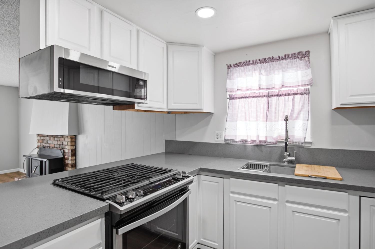 1436 Montclair Drive Modesto, CA 95350 - Photo 16 of 29 a kitchen with stainless steel appliances granite countertop a sink stove and microwave