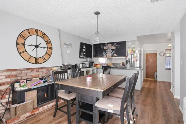 a dining room with wooden floor a glass table and chairs