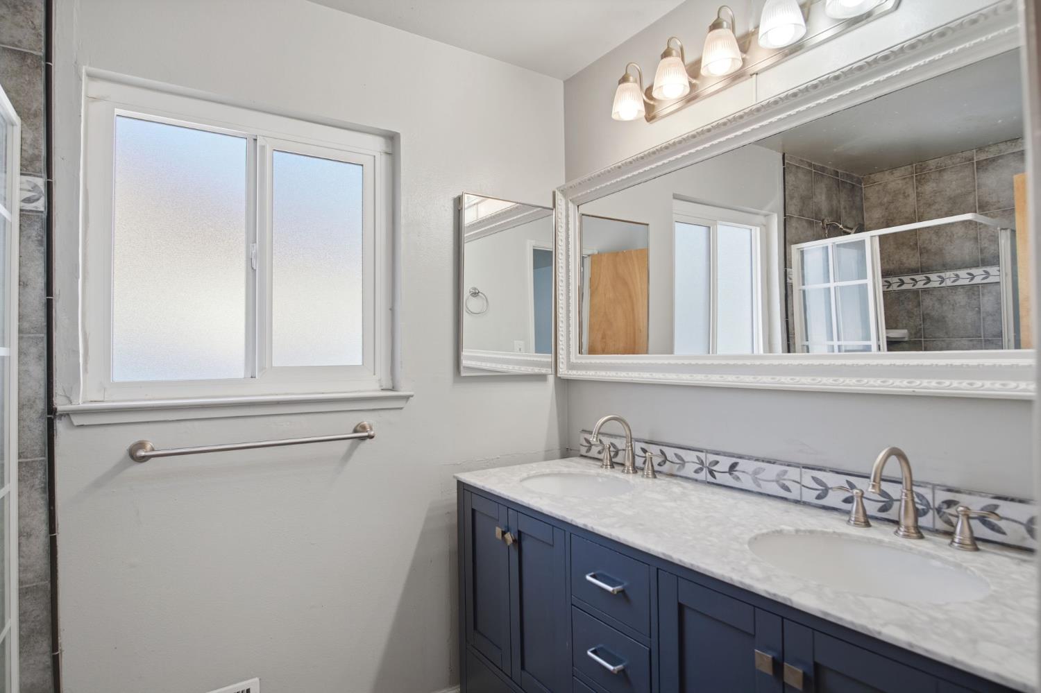 1436 Montclair Drive Modesto, CA 95350 - Photo 25 of 29 a bathroom with a granite countertop sink vanity and mirror