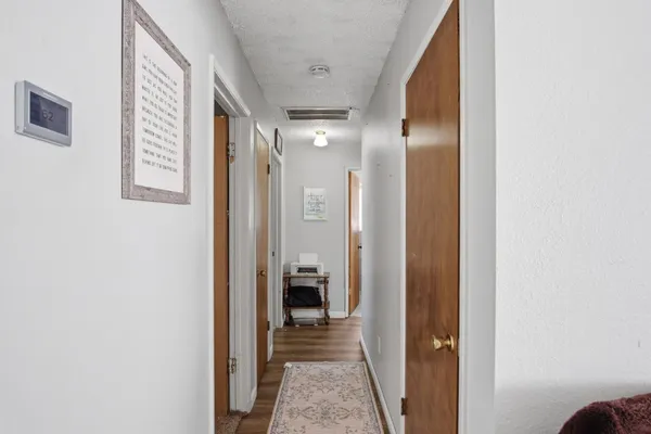 a view of a hallway with closet and a bathroom