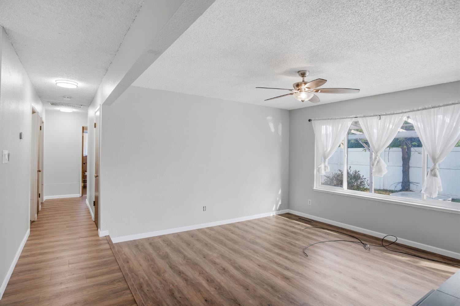 1436 Montclair Drive Modesto, CA 95350 - Photo 7 of 29 a view of an empty room with a window and wooden floor