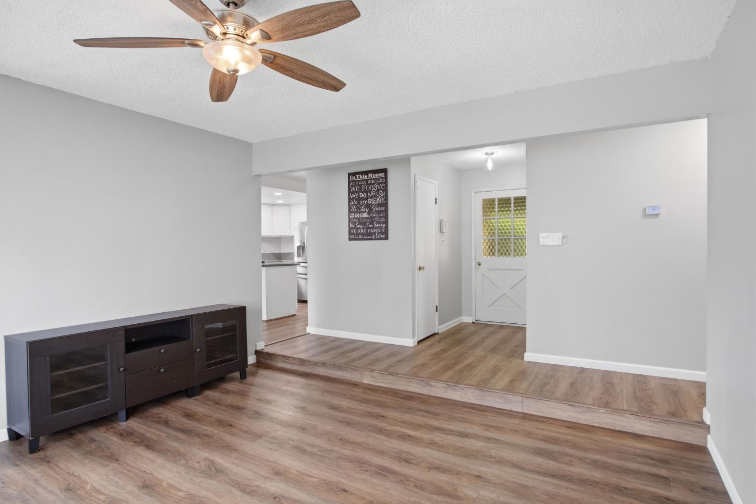 1436 Montclair Drive Modesto, CA 95350 - Photo 9 of 29 a view of an empty room with wooden floor and a ceiling fan