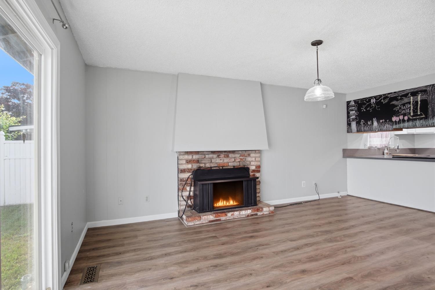 1436 Montclair Drive Modesto, CA 95350 - Photo 10 of 29 a view of a livingroom with wooden floor a fireplace and windows