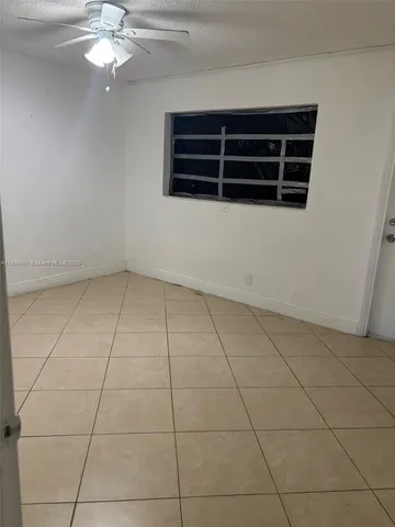 a view of an empty room with a cabinet and a rug