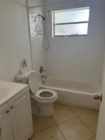 a bathroom with a granite countertop toilet a sink and a shower