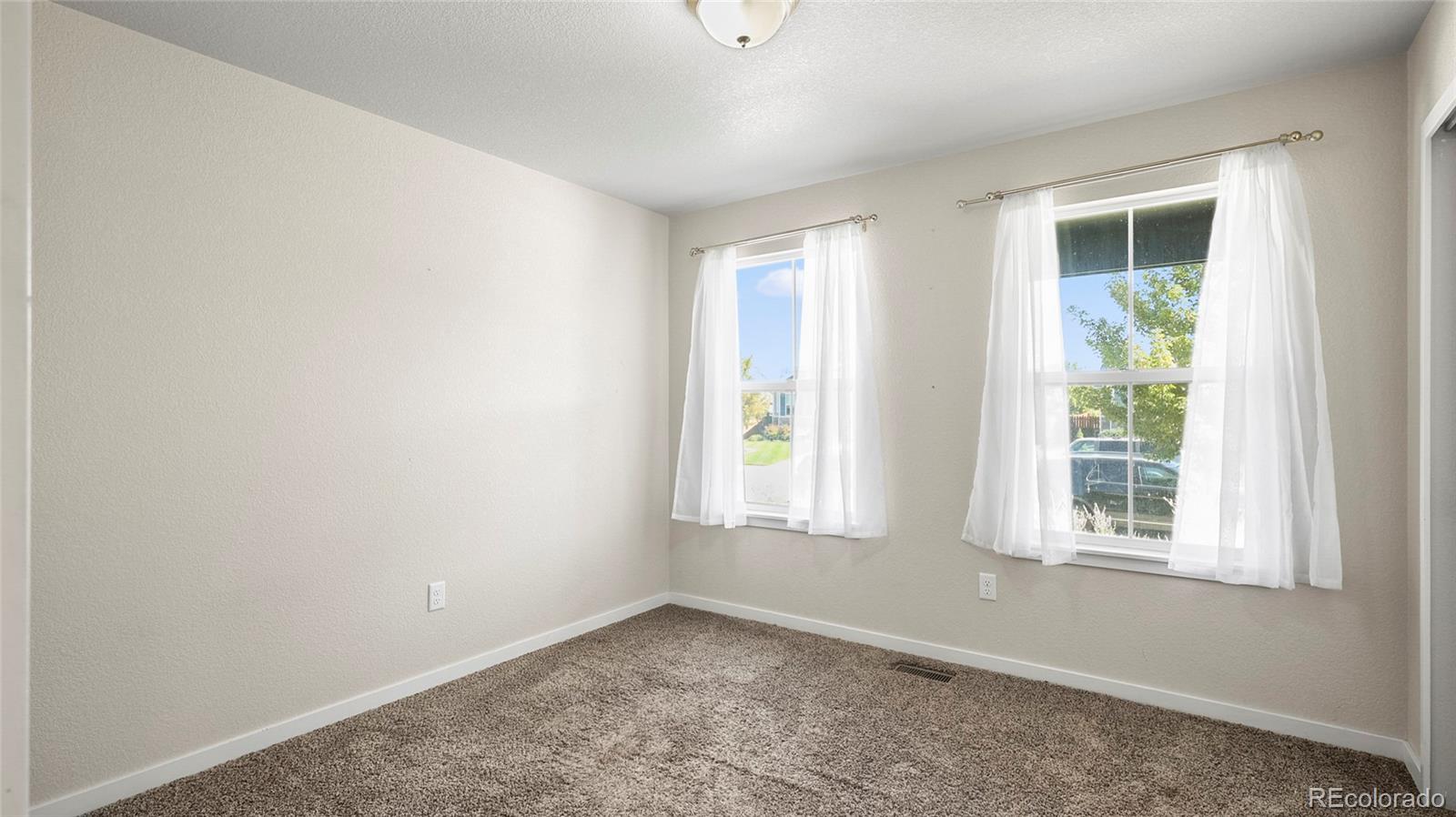 1106 Johnson Street Wiggins, CO 80654 - Photo 11 of 22 an empty room with windows