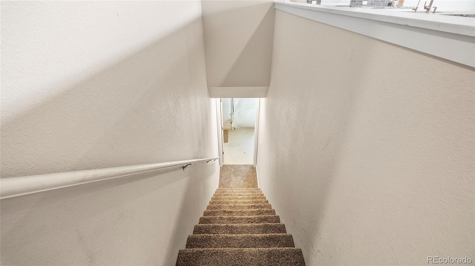 1106 Johnson Street Wiggins, CO 80654 - Photo 16 of 22 a view of a hallway with wooden floor and staircase