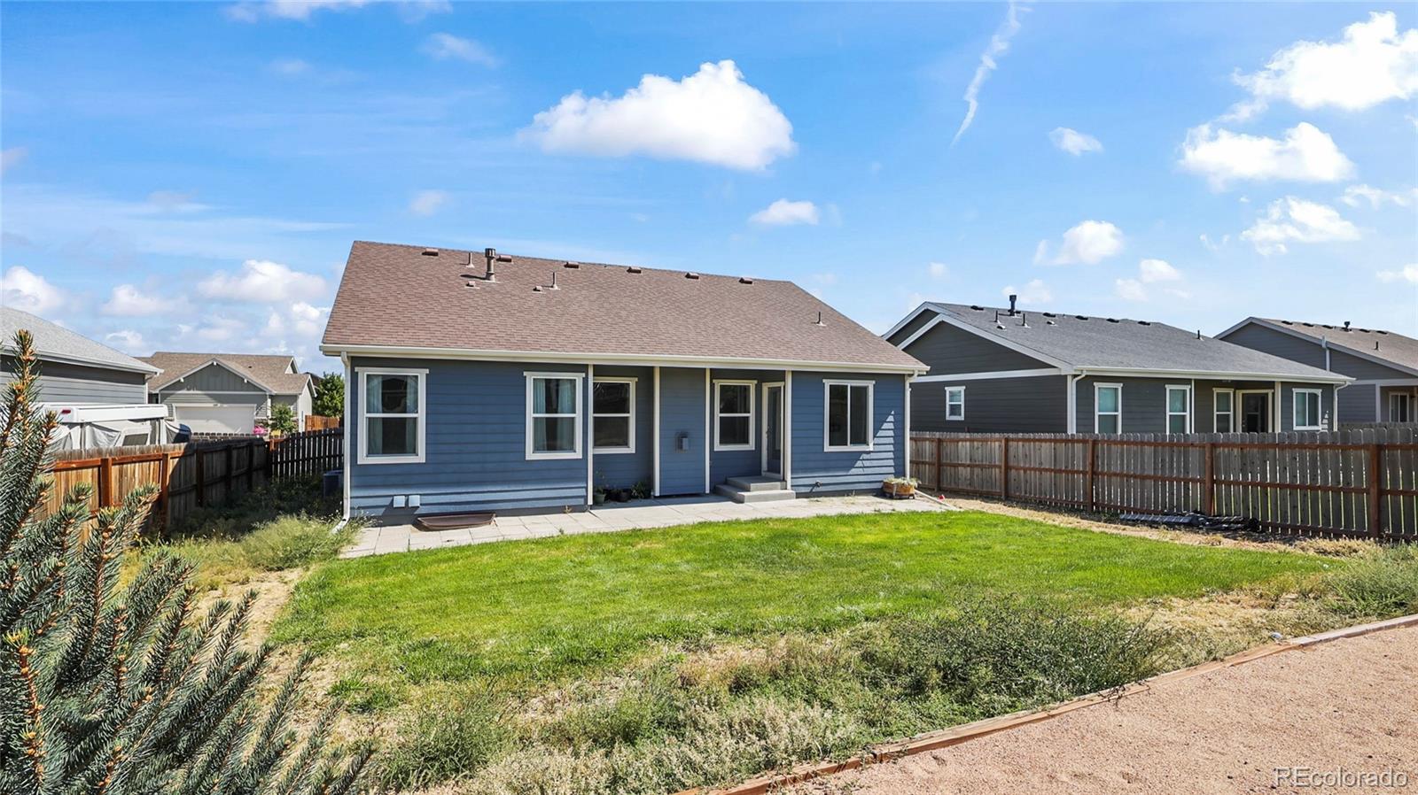 1106 Johnson Street Wiggins, CO 80654 - Photo 19 of 22 a front view of a house with a yard