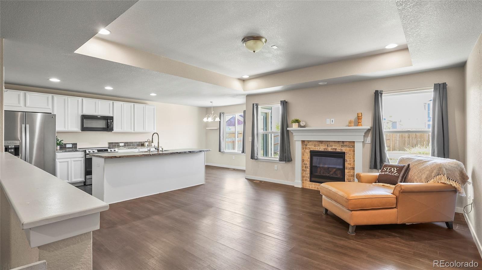 1106 Johnson Street Wiggins, CO 80654 - Photo 2 of 22 a living room with stainless steel appliances furniture and a fireplace