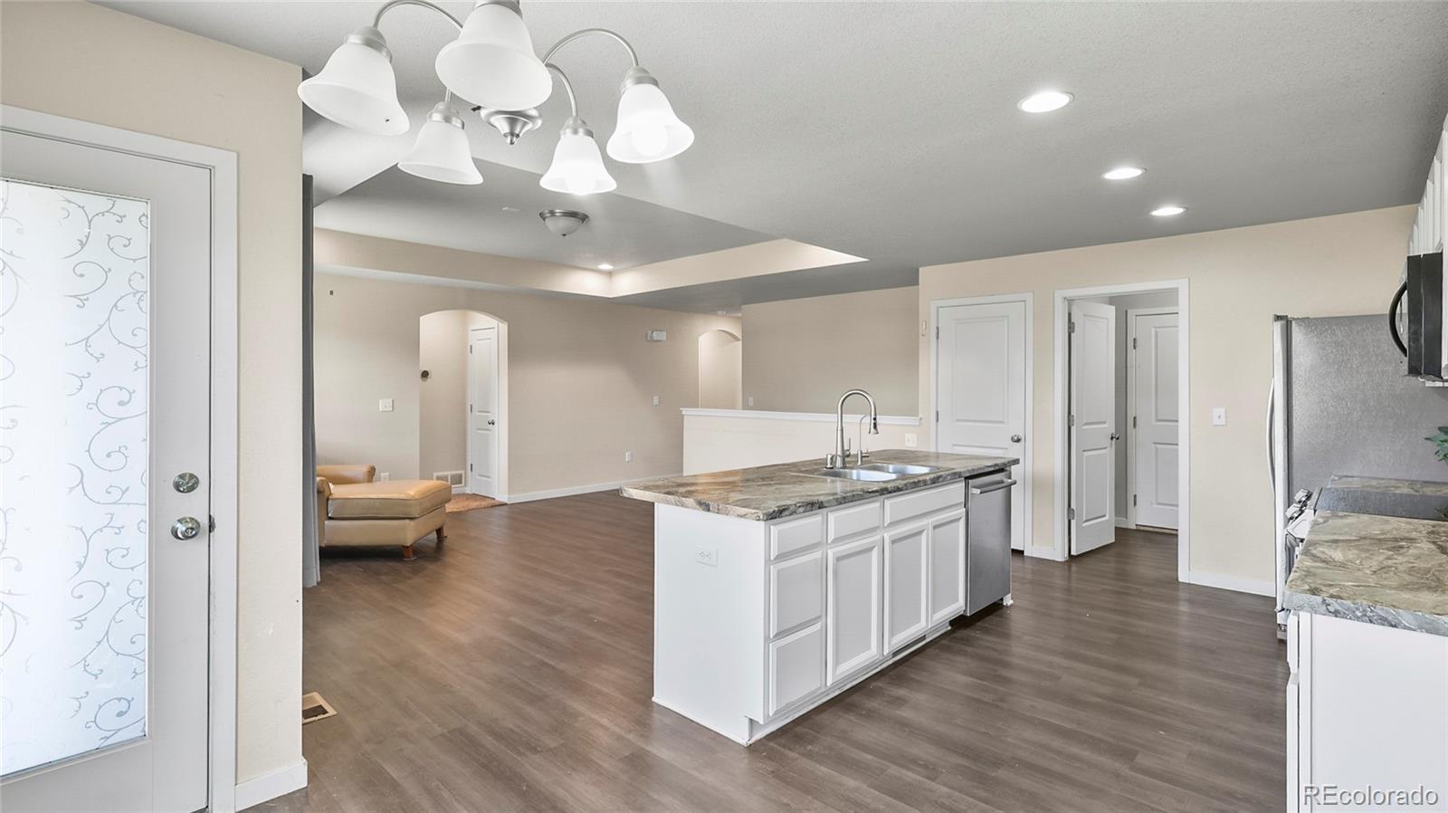 1106 Johnson Street Wiggins, CO 80654 - Photo 3 of 22 a kitchen with a stove a sink and a refrigerator