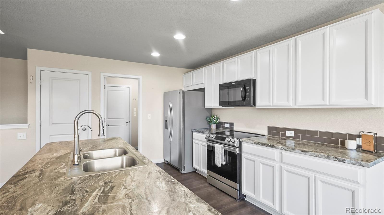 1106 Johnson Street Wiggins, CO 80654 - Photo 4 of 22 a kitchen with granite countertop a stove and a sink