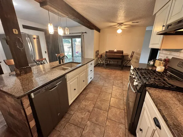 a kitchen with white cabinets and appliances