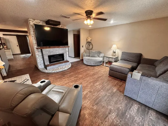 a living room with furniture a fireplace and a flat screen tv