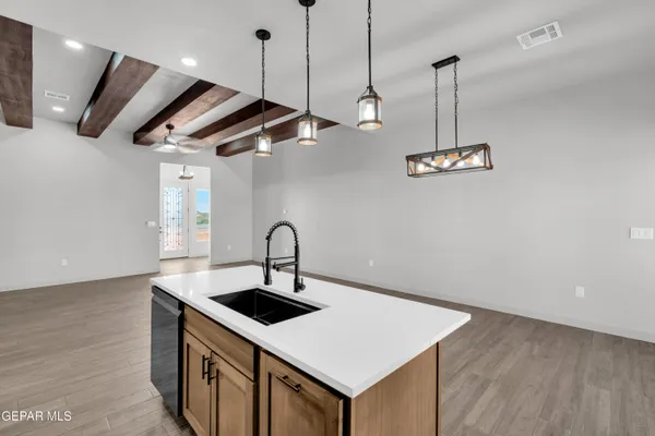 a kitchen with a sink a counter space a stove and wooden floor