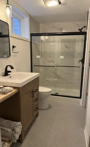 a bathroom with a sink a toilet and shower