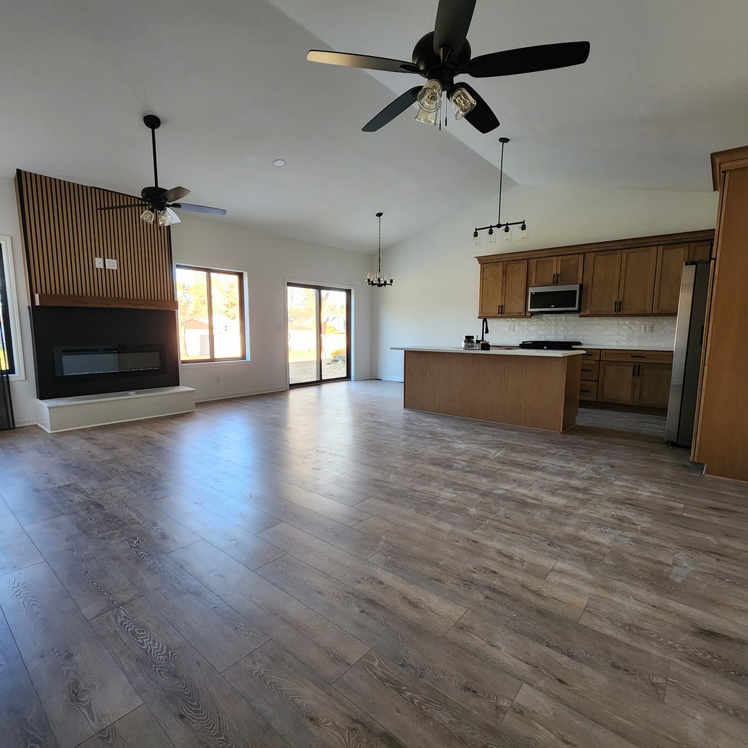 422 View Street Ottawa, IL 61350 - Photo 4 of 22 a view of a kitchen with a stove wooden floor a ceiling fan and windows