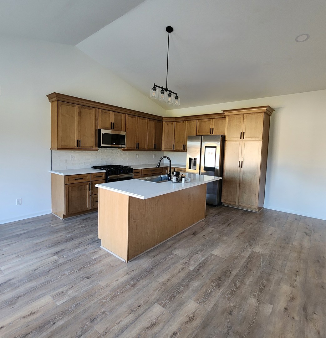 422 View Street Ottawa, IL 61350 - Photo 5 of 22 a kitchen with stainless steel appliances granite countertop a stove top oven a sink a refrigerator white cabinets and wooden floor